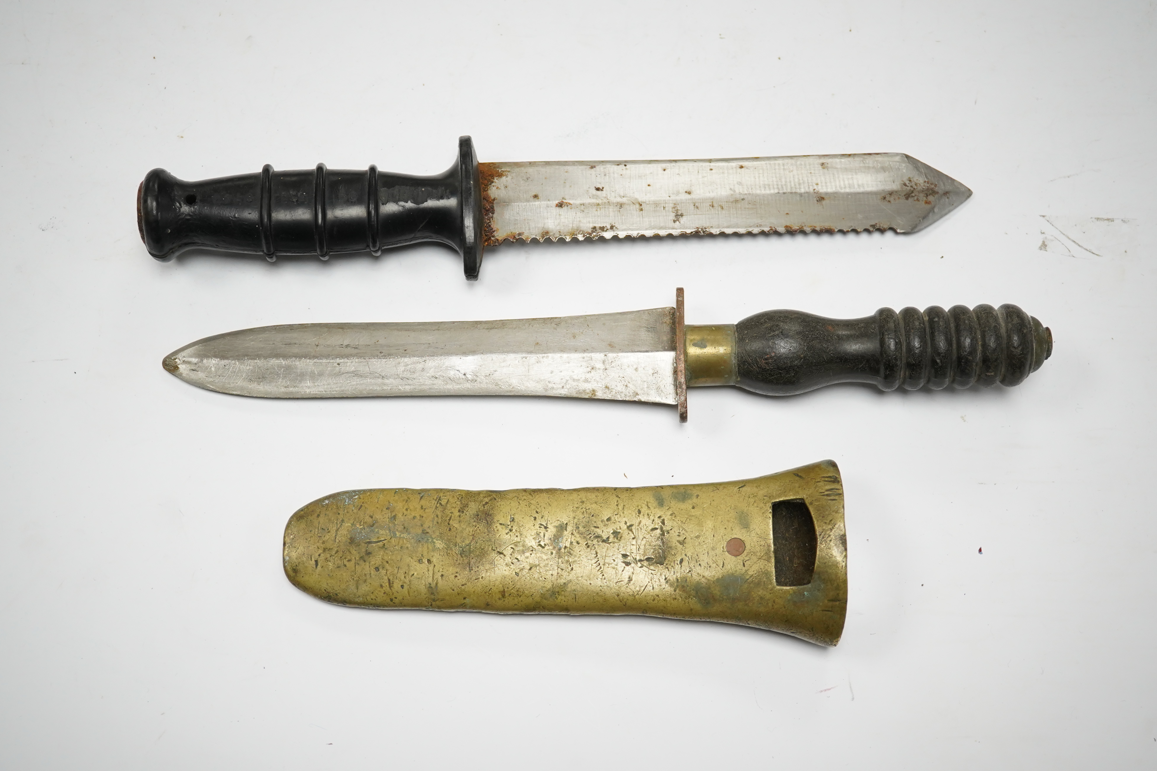 A Siebe Gorman & Co diving knife, regulation blade, turned wooden handle, brass cross piece with brass sheath, poor condition, together with another driver’s knife with sawback blade, etched John Noel and Sons, Sheffield